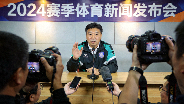体育新闻发布会上教练面对媒体回答问题的现场